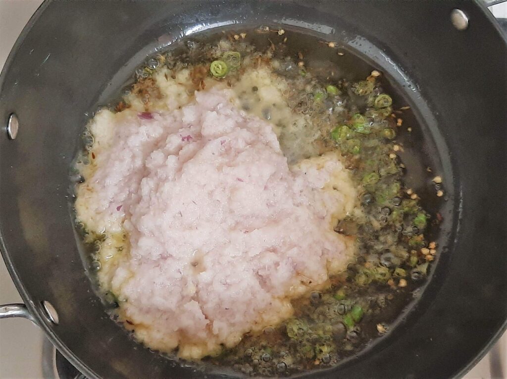Adding onion paste to a kadhai