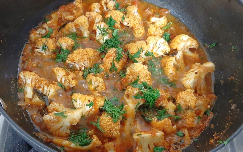 adding coriander in gobi masala