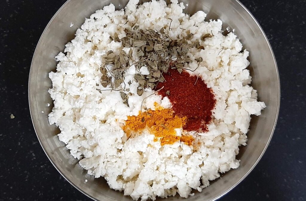 Adding spices in crushed paneer