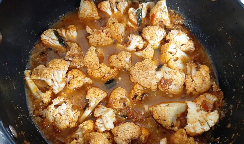 Making cauliflower masala curry